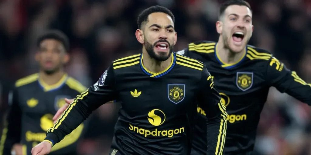 Manchester United players celebrating late winner against Arsenal at Emirates