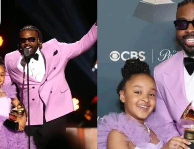 Aura V holding her Grammy Award on stage with her father Fyütch